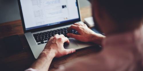 A man sitting at the computer making a donation to FIH's